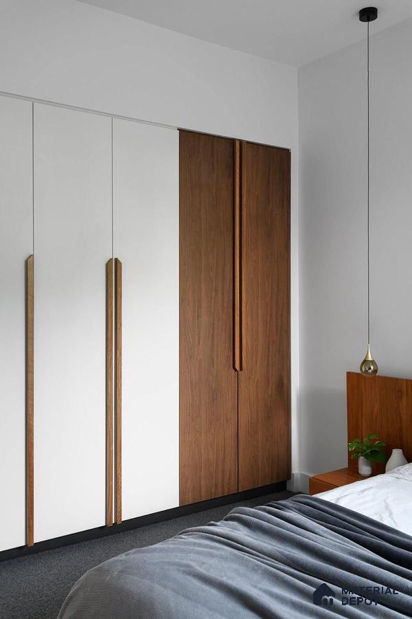 Minimalist bedroom with white and walnut brown laminate wardrobe and grey carpet flooring | Material Depot