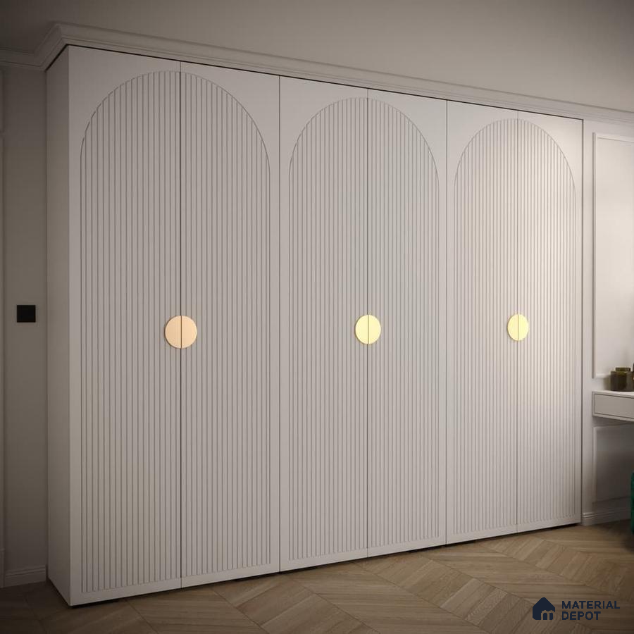 Minimalist white fluted wardrobe with gold circular handles and herringbone wooden flooring | Material Depot