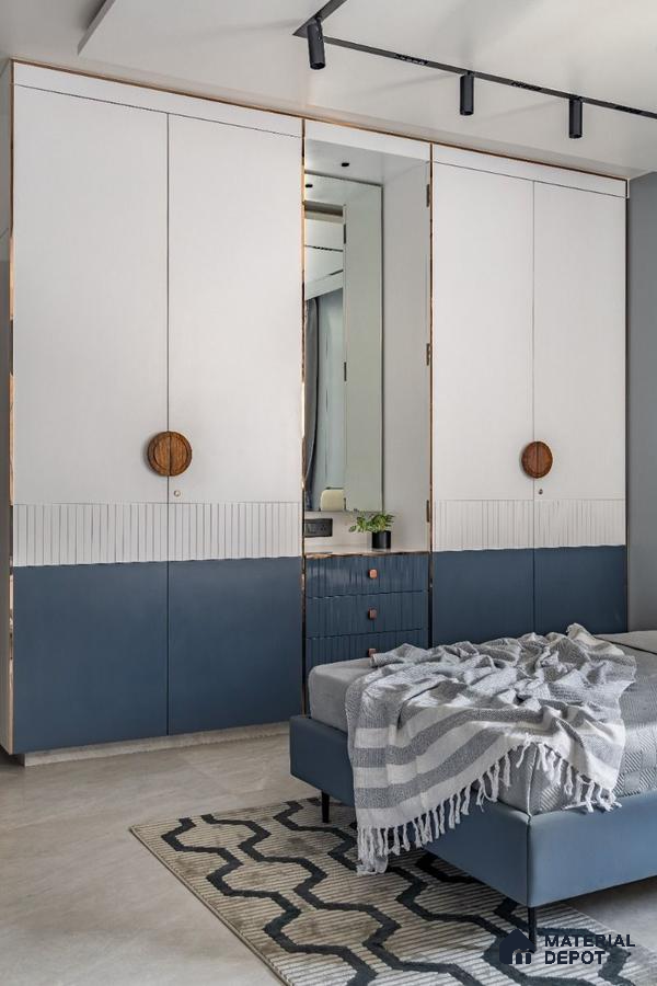 Modern bedroom with dual-tone white and blue laminate wardrobe and geometric rug | Material Depot