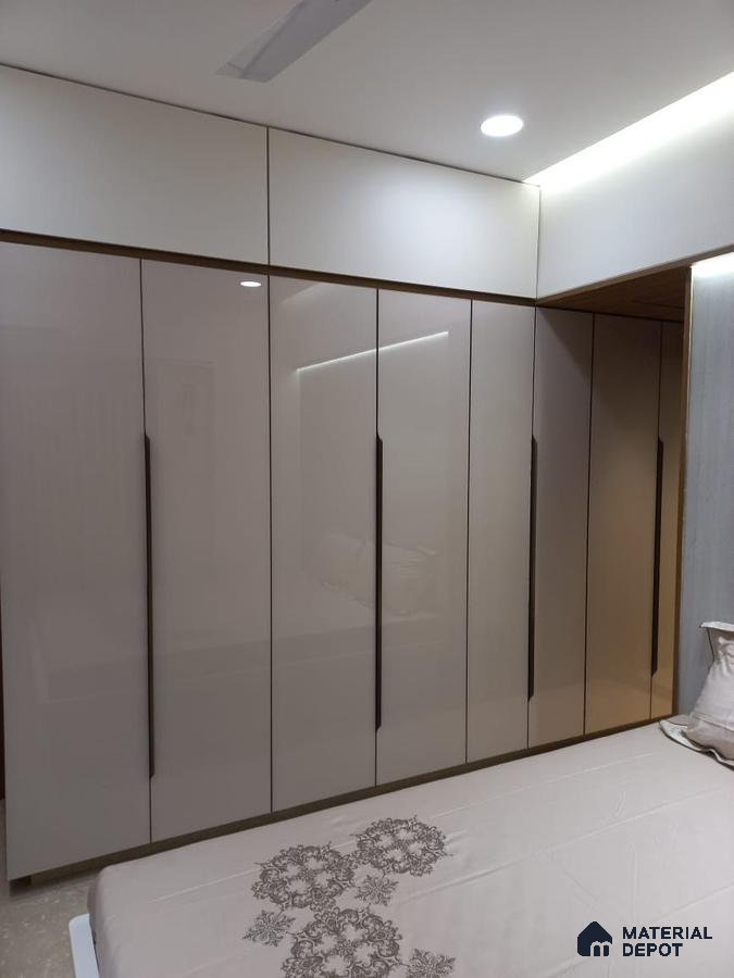 Modern bedroom with high gloss beige laminate wardrobe and white overhead cabinets | Material Depot