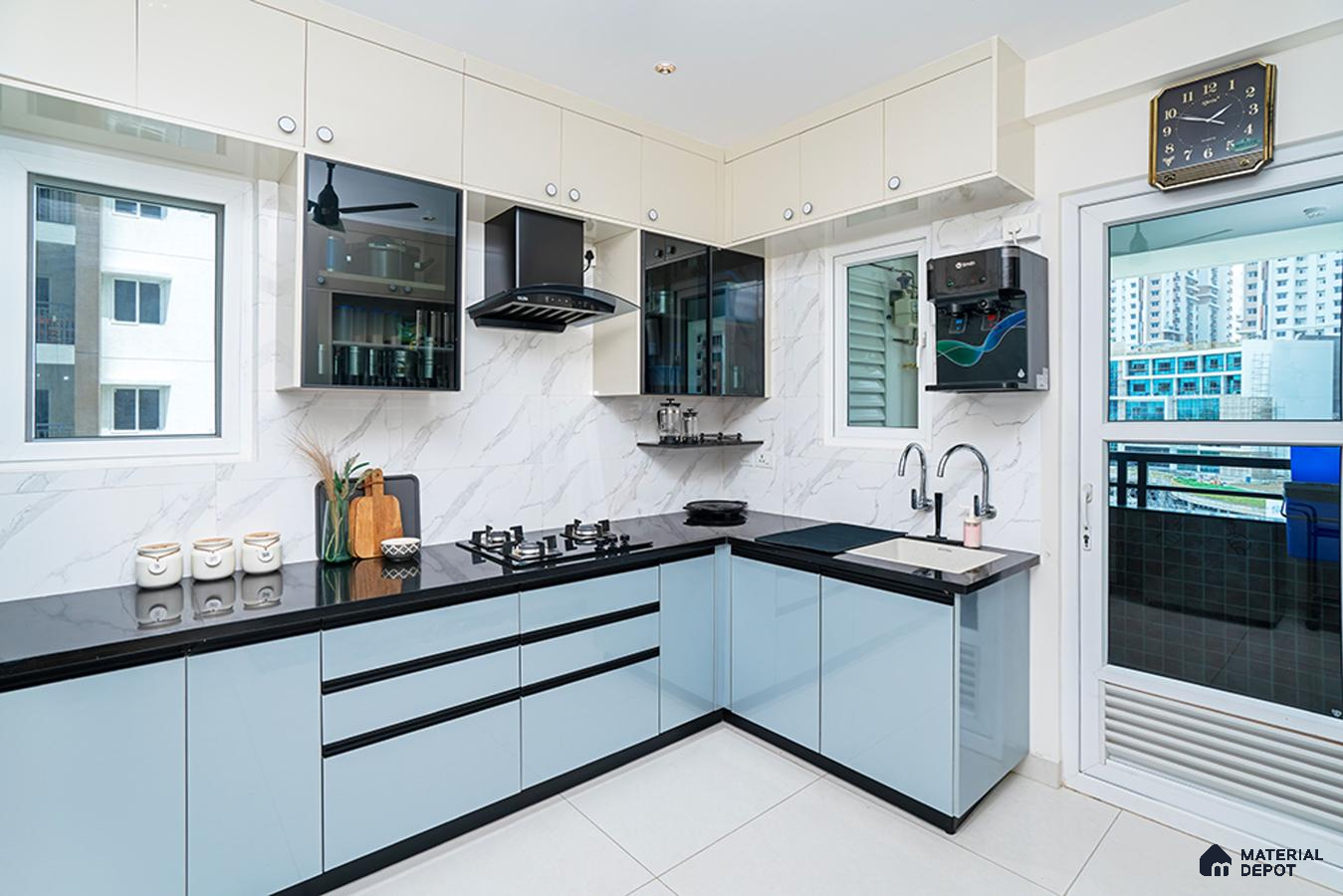 Modern dual tone kitchen with pastel blue and frosty white high gloss laminate, black quartz countertop, and marble-look backsplash tile in Bengaluru | Material Depot