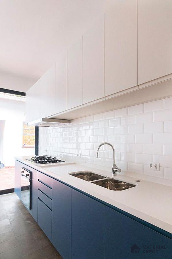 Modern kitchen with blue laminate base cabinets, white laminate wall cabinets, and white subway tile backsplash in Bengaluru | Material Depot