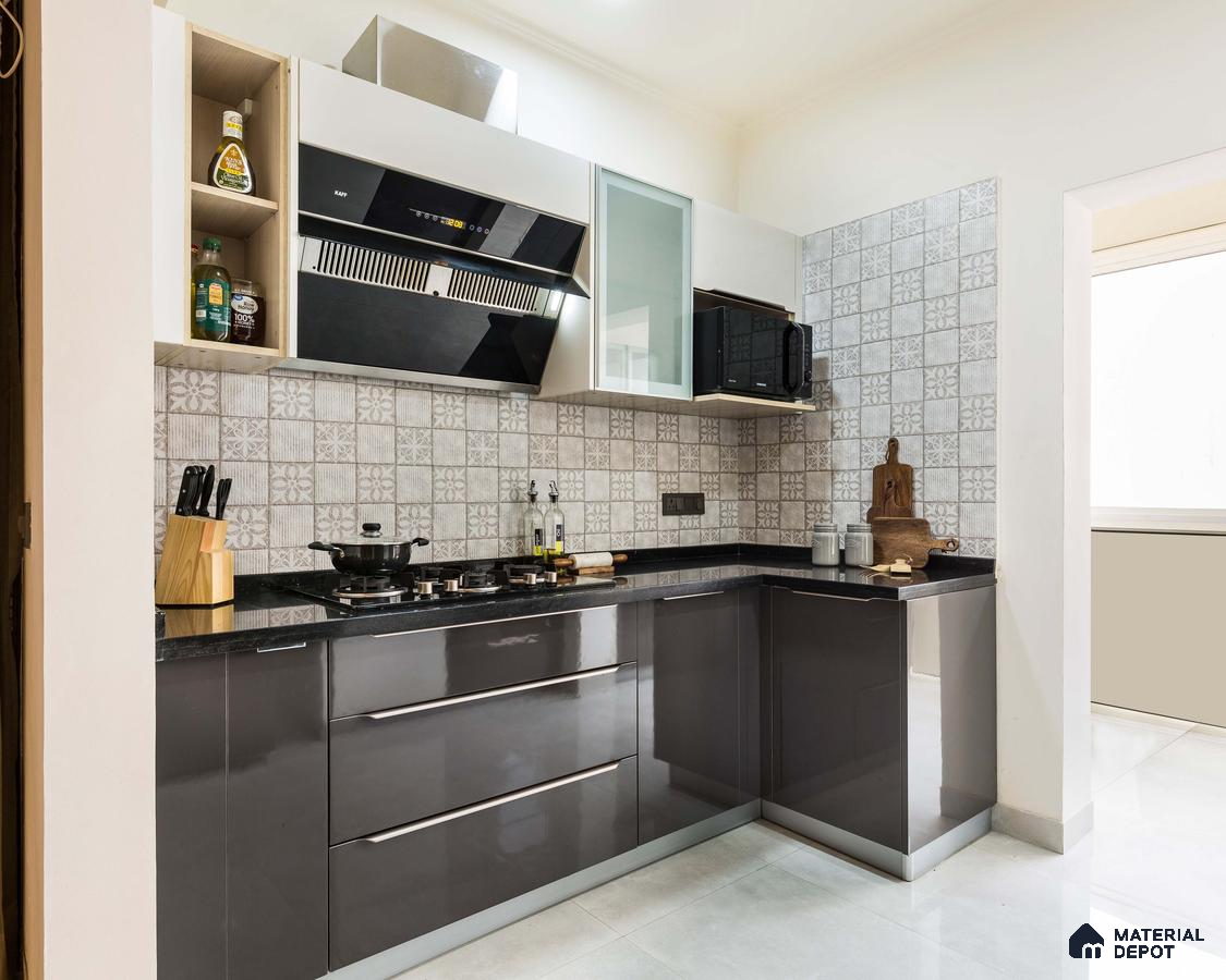 Modern kitchen with grey high gloss laminate, black granite countertop, and patterned grey backsplash tiles in Bengaluru | Material Depot