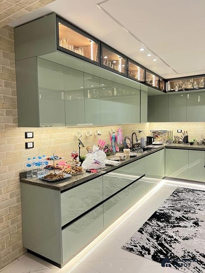 Modern kitchen with sage green high gloss laminate cabinets, brick look wall tiles, and black granite countertop in Bengaluru | Material Depot