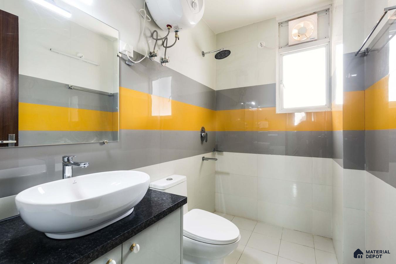Spacious bathroom with high gloss yellow, grey, and white tiles, featuring a mirror and exhaust fan for a functional and serene ambiance.