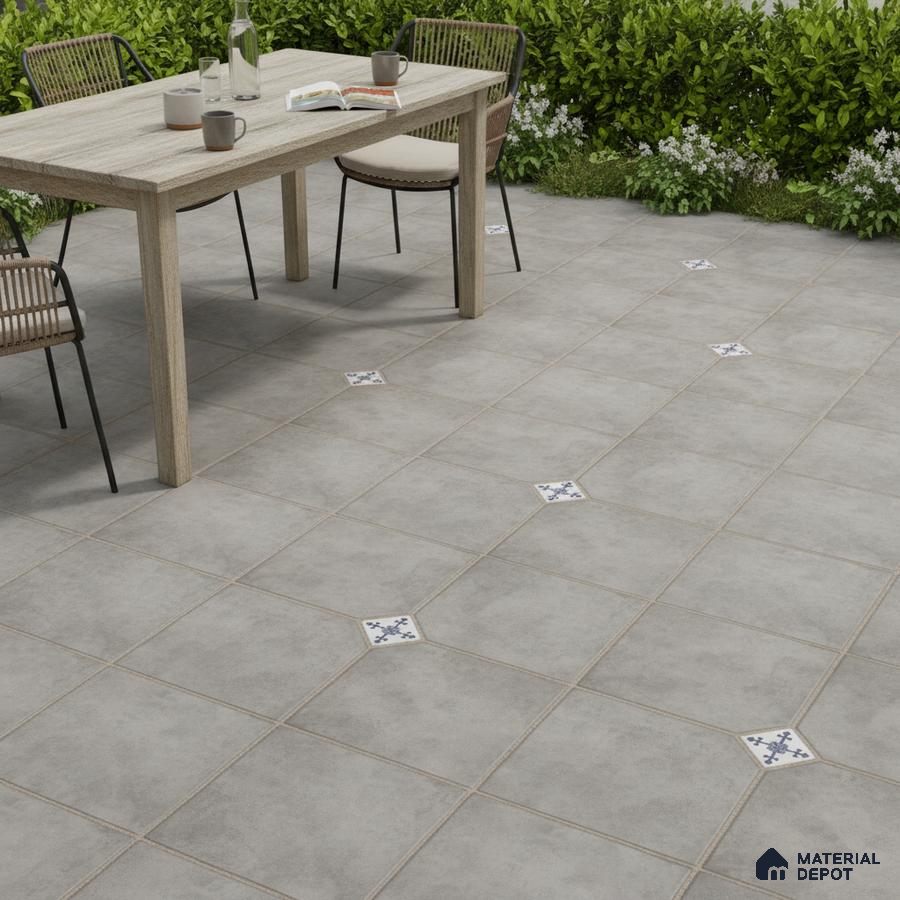 Minimalist outdoor space with grey stone-look floor tiles and blue patterned accent inserts