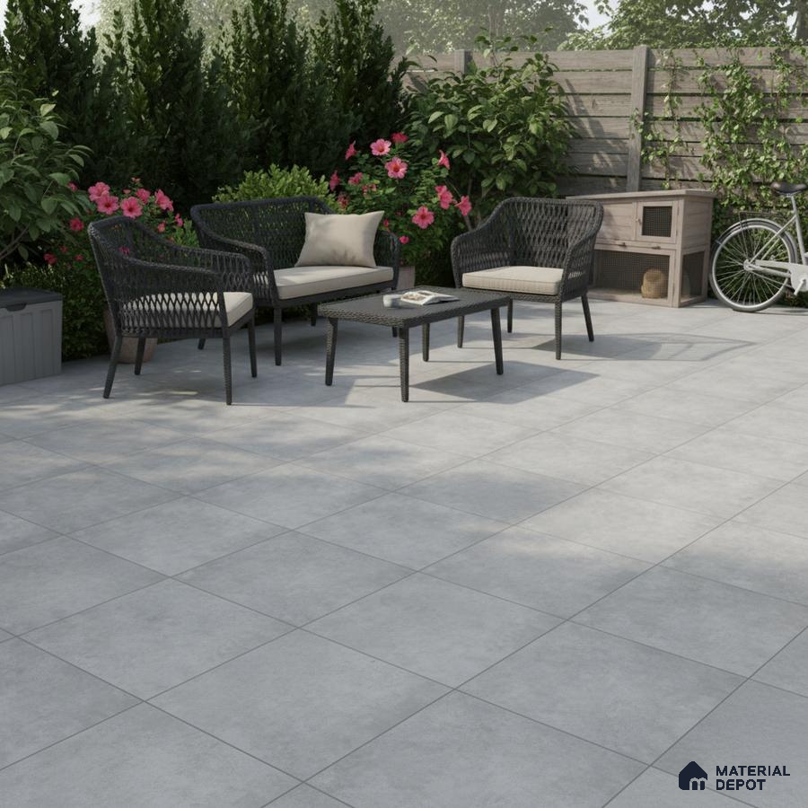 Modern outdoor patio with light grey stone-look floor tiles and wicker furniture